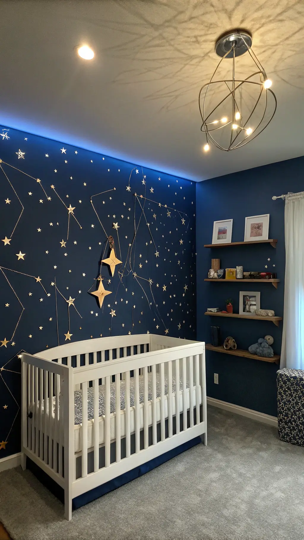 Twilight blue Cosmic Adventures nursery with a midnight blue accent wall, white crib under a celestial mobile, LED-lit floating shelves and constellation-patterned bedding in focus.