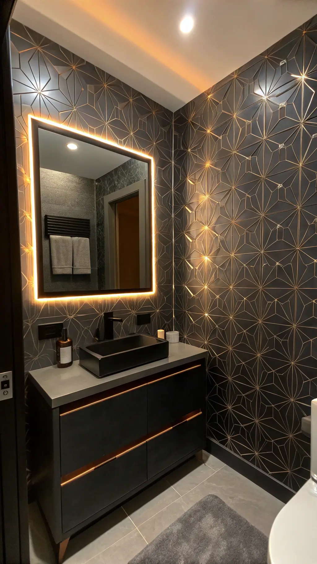 Compact powder room illuminated by LED strips with metallic geometric wallpaper, backlit mirror with touch controls, and hidden speakers, featuring a monochrome palette with copper accents.