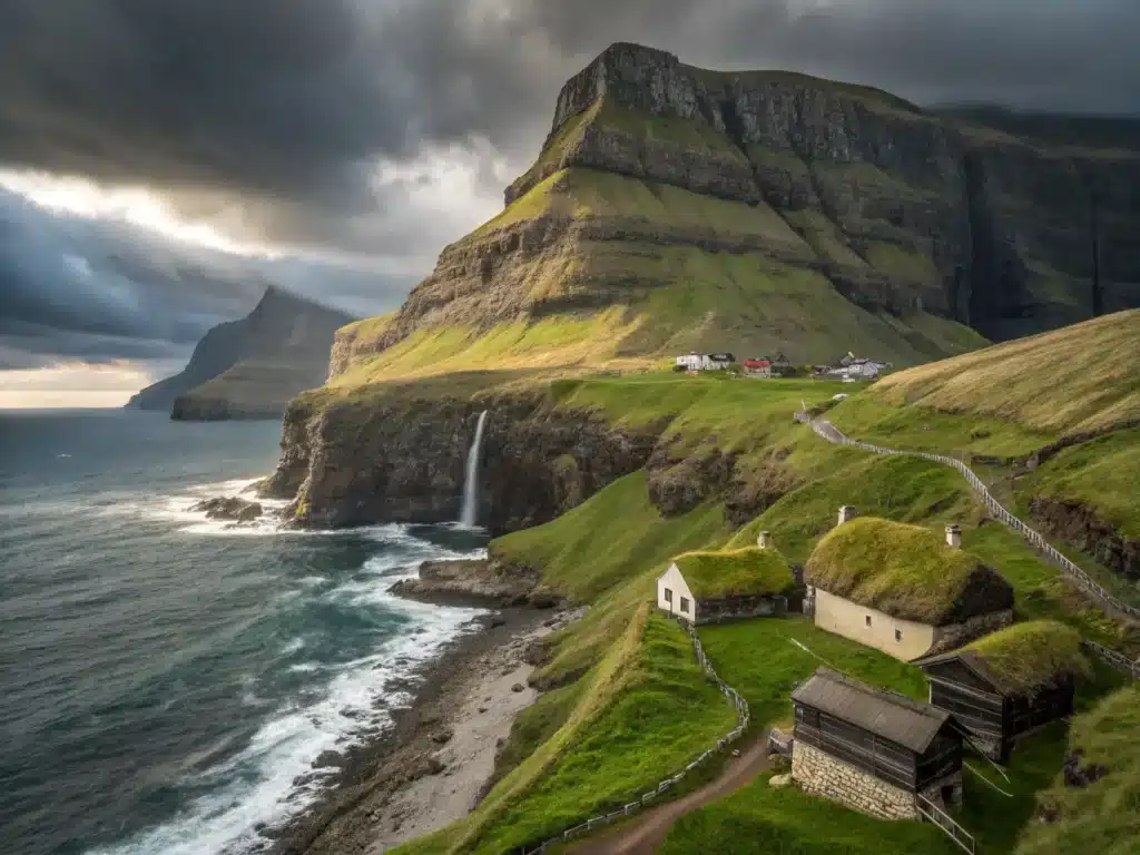 "Aerial view of a remote Faroese village with traditional turf-roof houses against green cliffs and stormy North Atlantic Ocean, bathed in fleeting sunlight under heavy grey clouds, with cascading waterfalls and wildflowers on foggy mountain peaks"
